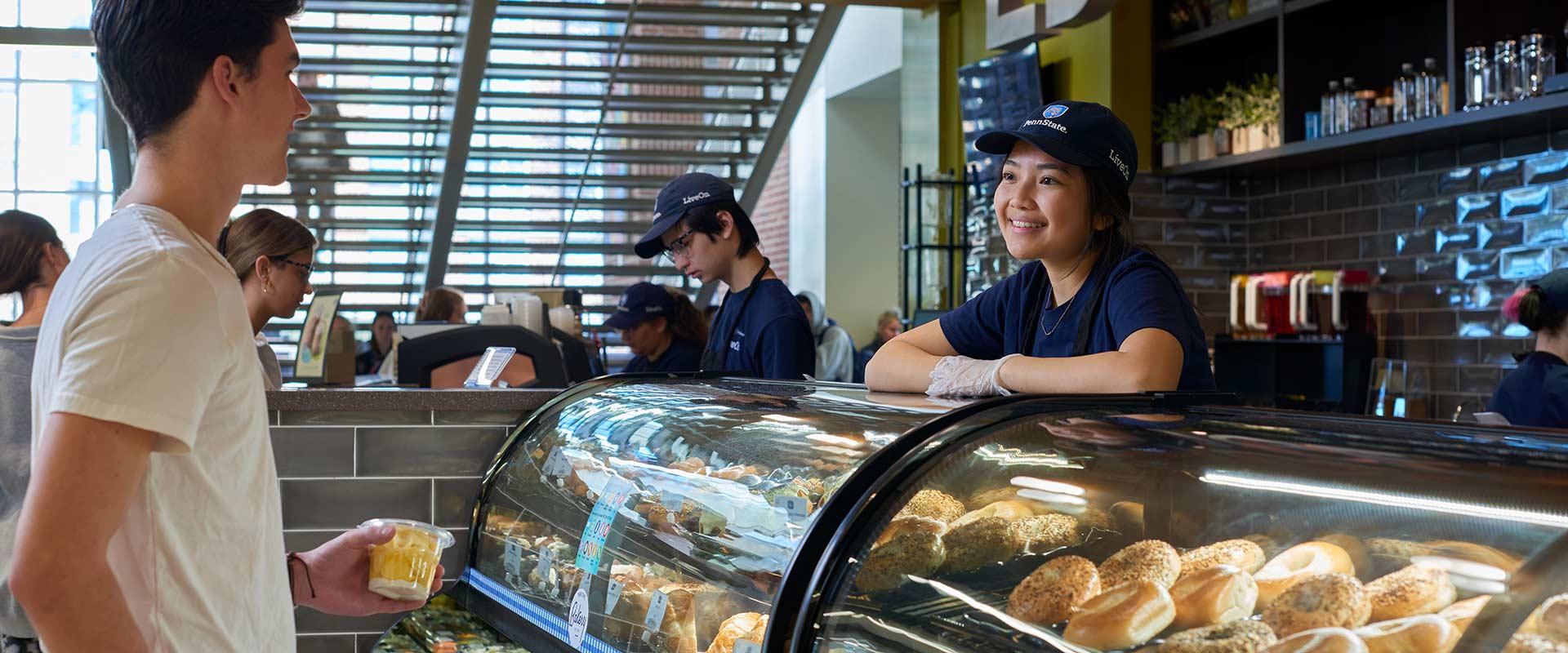 Student employee helps customer at campus cafe Student employee helps customer at campus cafe